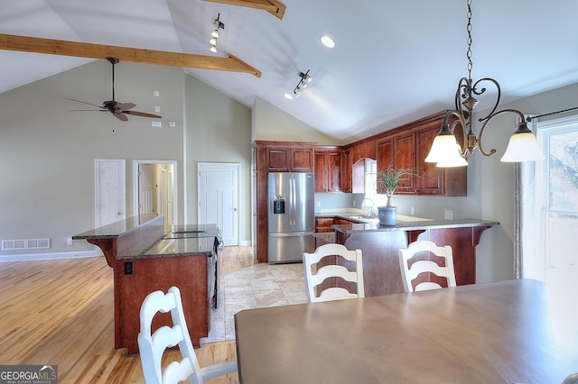 kitchen featuring stainless steel appliances, a breakfast bar area, hanging light fixtures, and plenty of natural light