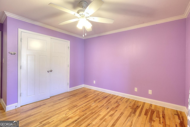 unfurnished bedroom featuring crown molding, ceiling fan, light hardwood / wood-style floors, and a closet