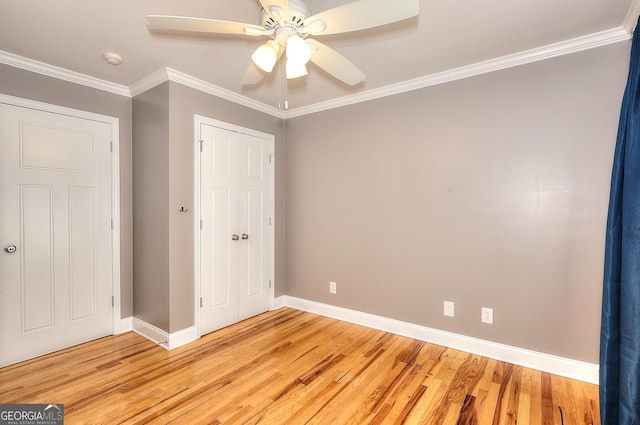 unfurnished bedroom with crown molding, a closet, ceiling fan, and light wood-type flooring