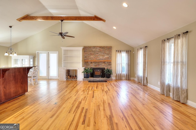 unfurnished living room with beamed ceiling, a wealth of natural light, high vaulted ceiling, and light wood-type flooring