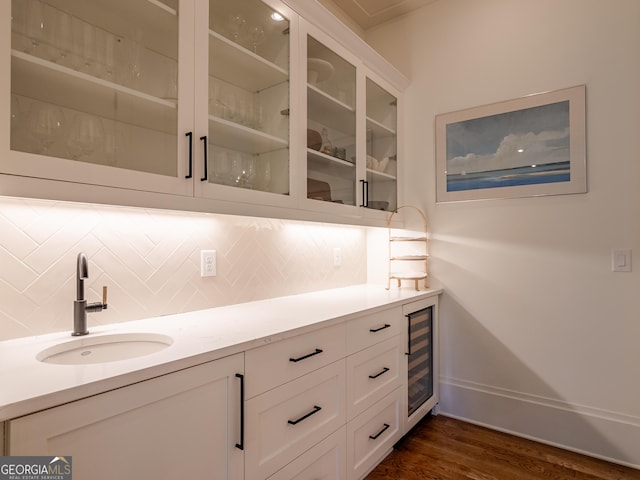 bar with dark hardwood / wood-style floors, white cabinetry, sink, wine cooler, and backsplash