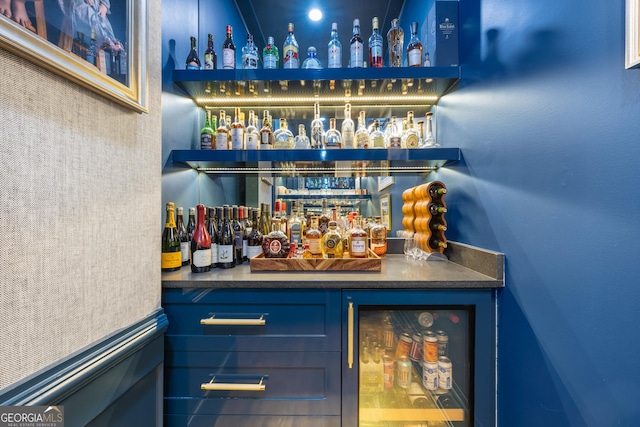 bar featuring beverage cooler and blue cabinets