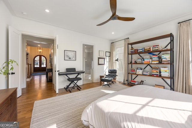 bedroom with connected bathroom, hardwood / wood-style flooring, french doors, and ceiling fan