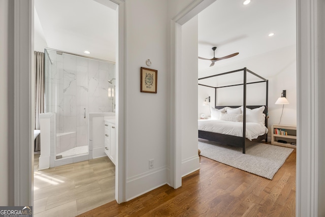 bedroom with hardwood / wood-style floors and ensuite bath