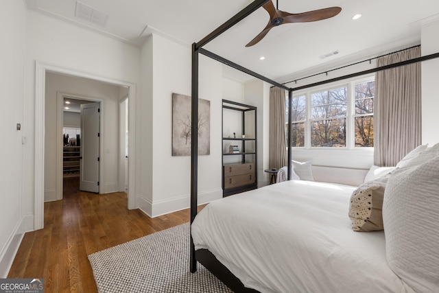 bedroom featuring ornamental molding, dark wood-type flooring, and ceiling fan