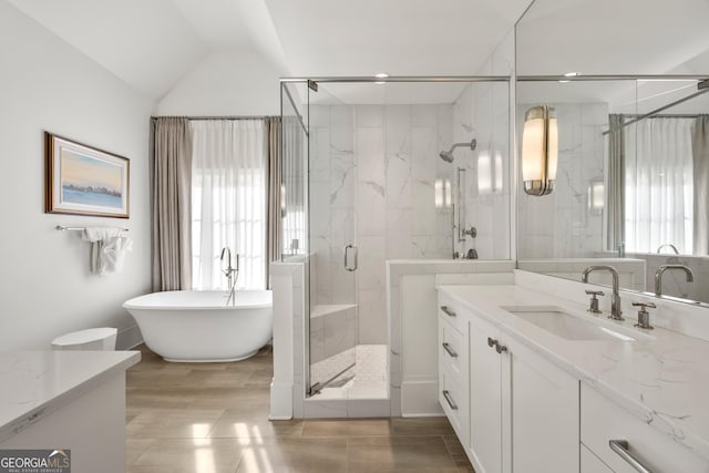 bathroom with vanity, vaulted ceiling, shower with separate bathtub, and a healthy amount of sunlight