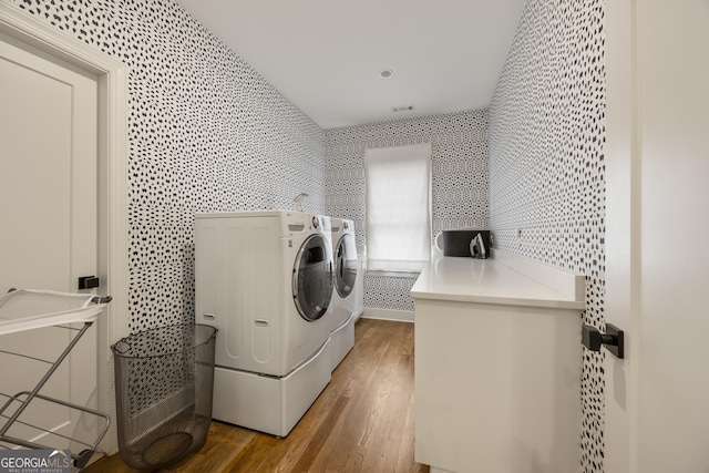 laundry area featuring washing machine and clothes dryer and wood-type flooring