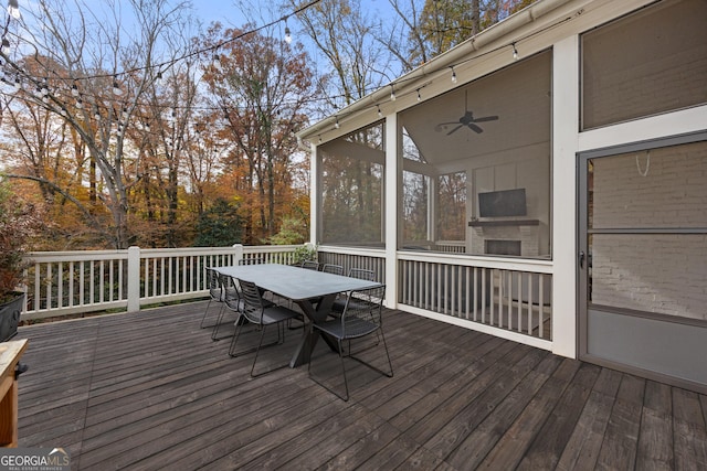 wooden terrace with a sunroom and ceiling fan