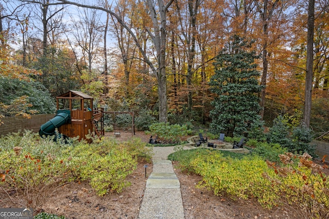 view of yard featuring an outdoor fire pit and a playground