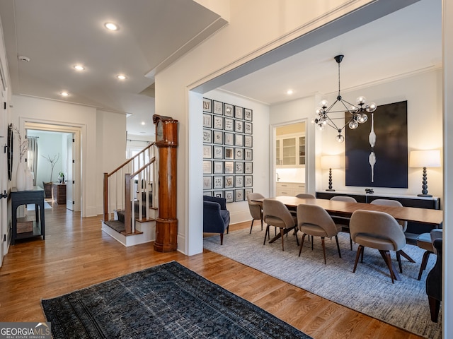 dining space featuring hardwood / wood-style flooring, crown molding, and a notable chandelier