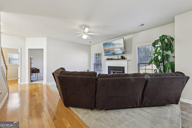 living room featuring light hardwood / wood-style flooring and ceiling fan