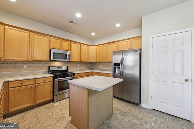 kitchen with tasteful backsplash, appliances with stainless steel finishes, and a center island