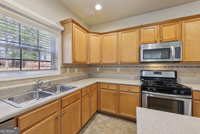 kitchen with tasteful backsplash, sink, and appliances with stainless steel finishes