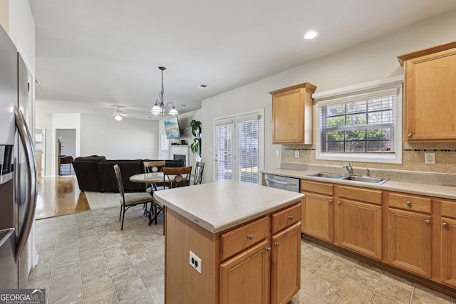 kitchen with sink, decorative light fixtures, a kitchen island, stainless steel appliances, and backsplash