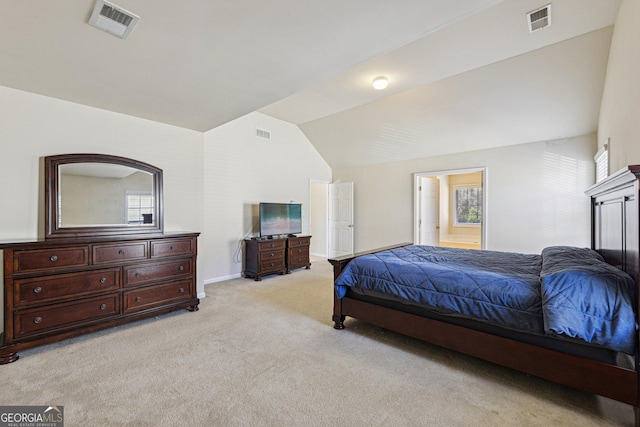 bedroom featuring multiple windows, ensuite bathroom, lofted ceiling, and light colored carpet