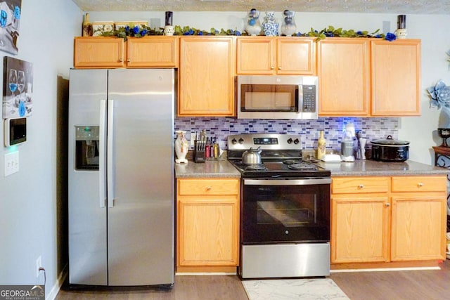 kitchen featuring tasteful backsplash, appliances with stainless steel finishes, and light brown cabinetry