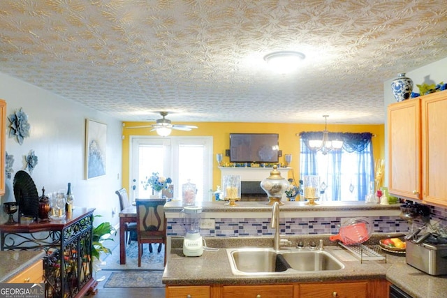 kitchen with light brown cabinetry, sink, decorative backsplash, and a wealth of natural light