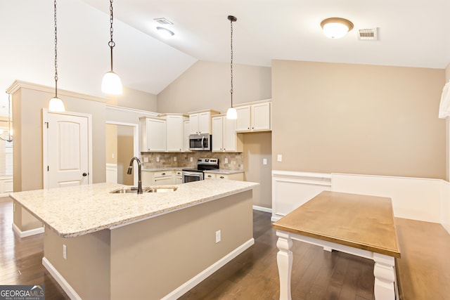 kitchen with sink, hanging light fixtures, stainless steel appliances, a kitchen island with sink, and white cabinets