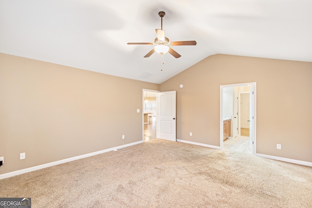 unfurnished bedroom with lofted ceiling, ensuite bath, light colored carpet, and ceiling fan