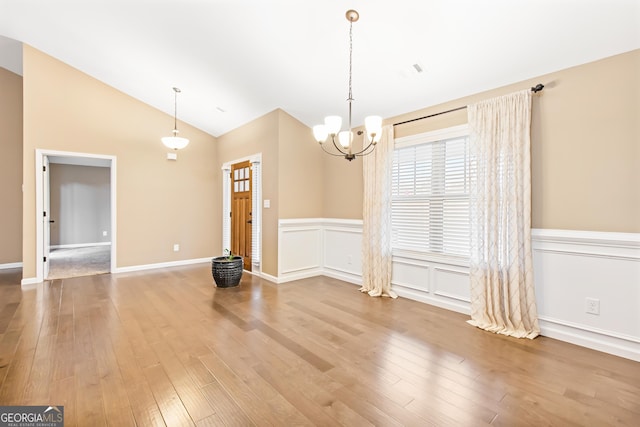 interior space with lofted ceiling, hardwood / wood-style floors, and a notable chandelier