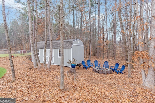 view of yard with a shed and a fire pit