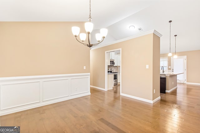 unfurnished dining area with vaulted ceiling, a notable chandelier, and light wood-type flooring