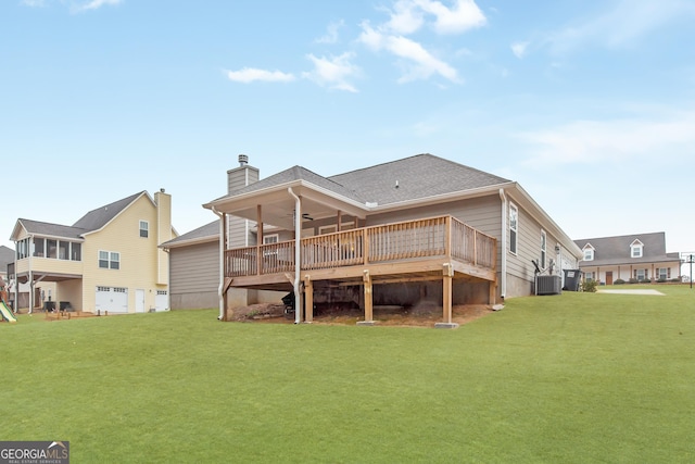 rear view of property with ceiling fan, a deck, and a lawn