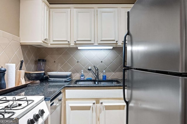 kitchen featuring sink, appliances with stainless steel finishes, white cabinetry, dark stone countertops, and tasteful backsplash