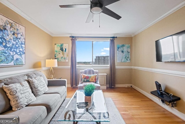 living room with crown molding, ceiling fan, and light hardwood / wood-style floors