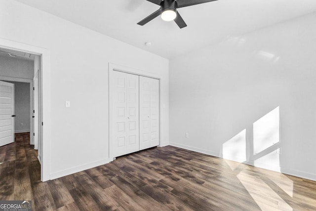 unfurnished bedroom with dark wood-type flooring, ceiling fan, and a closet