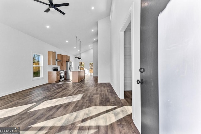 unfurnished living room featuring dark hardwood / wood-style flooring, high vaulted ceiling, and ceiling fan