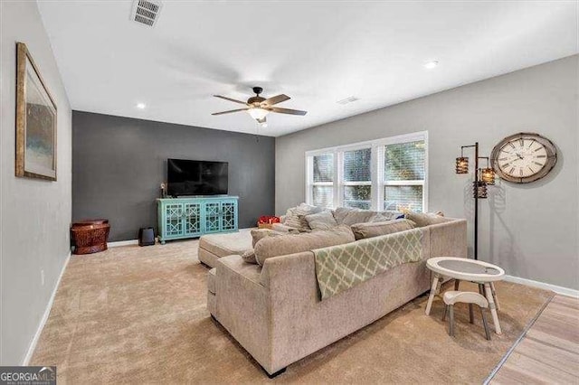 living room with ceiling fan and light colored carpet