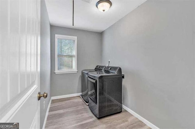 washroom featuring independent washer and dryer and light hardwood / wood-style flooring