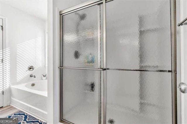 bathroom featuring independent shower and bath and hardwood / wood-style floors