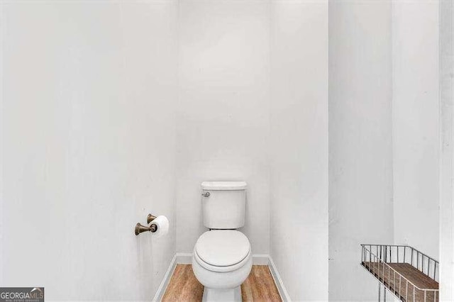 bathroom with hardwood / wood-style floors and toilet