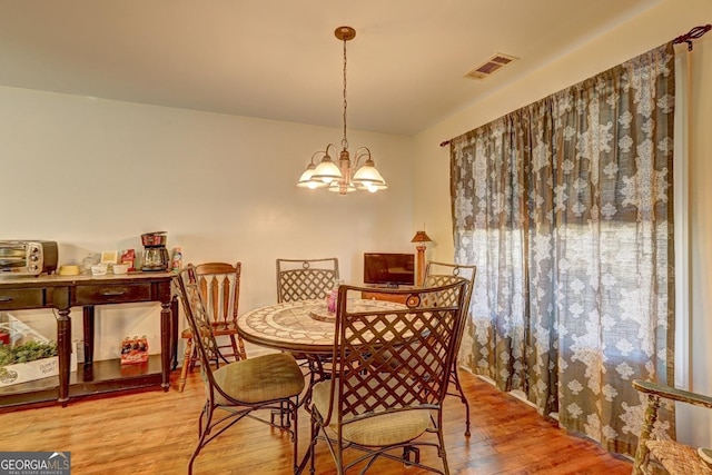 dining room featuring an inviting chandelier and light hardwood / wood-style flooring