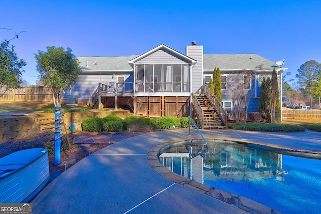 view of pool with a wooden deck, a patio area, and a sunroom