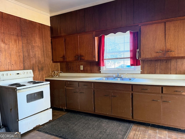 kitchen with ornamental molding, sink, wood walls, and electric stove