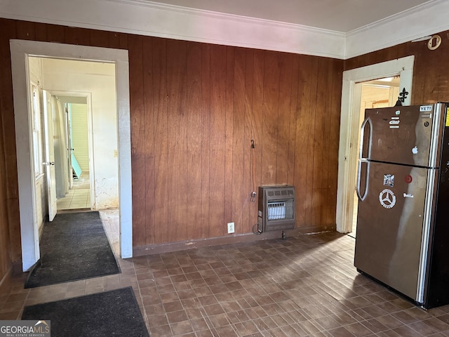 kitchen featuring wooden walls, stainless steel fridge, and heating unit