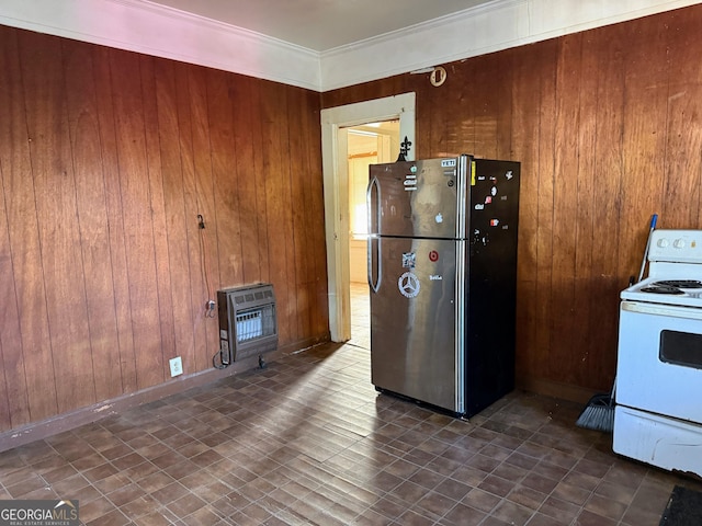 kitchen with stainless steel refrigerator, white electric range, wooden walls, and heating unit