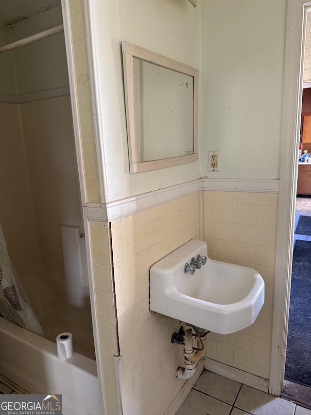 bathroom featuring tile patterned flooring, sink, tile walls, and shower / bath combination with curtain