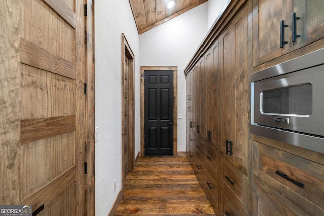 hall with wood ceiling, vaulted ceiling, and dark hardwood / wood-style floors