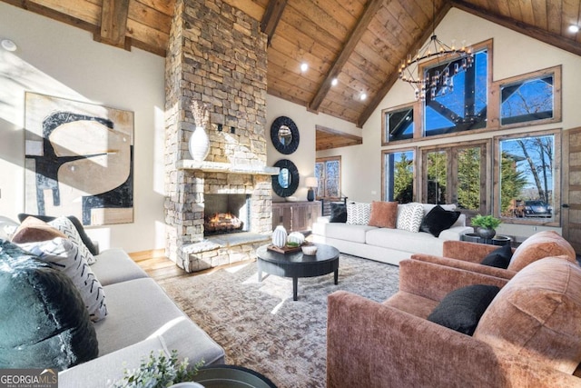 living room featuring beamed ceiling, wood ceiling, a chandelier, hardwood / wood-style flooring, and a fireplace