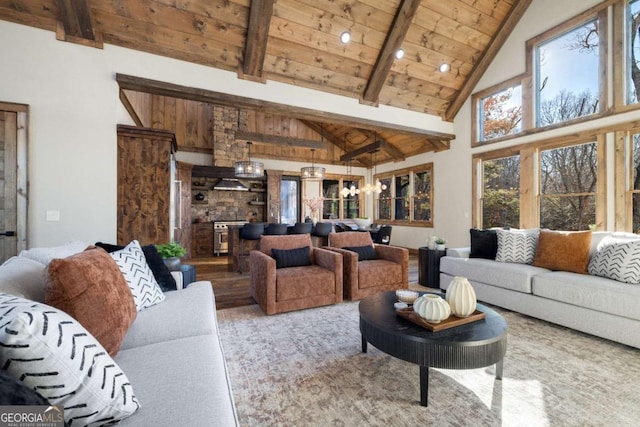 living room featuring wood ceiling, beam ceiling, a chandelier, and high vaulted ceiling