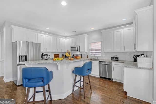 kitchen with sink, white cabinetry, a center island, a kitchen breakfast bar, and stainless steel appliances