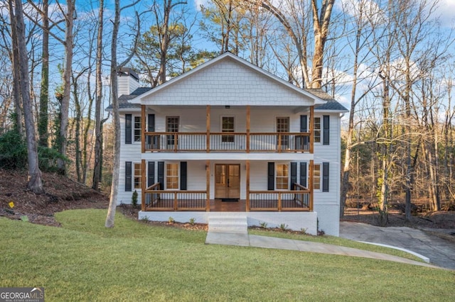 view of front of house with a porch, a balcony, and a front lawn