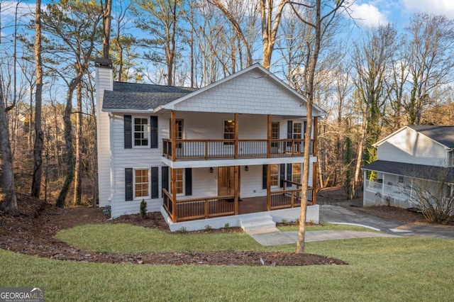 back of property with a porch, a yard, and a balcony