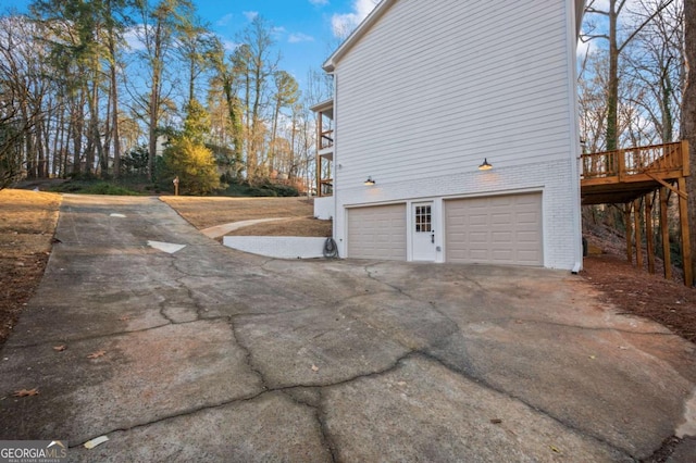 view of property exterior featuring a garage and a deck