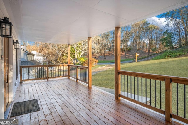 wooden deck featuring a lawn