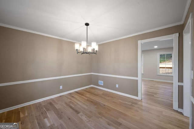 empty room with an inviting chandelier, ornamental molding, and light hardwood / wood-style floors